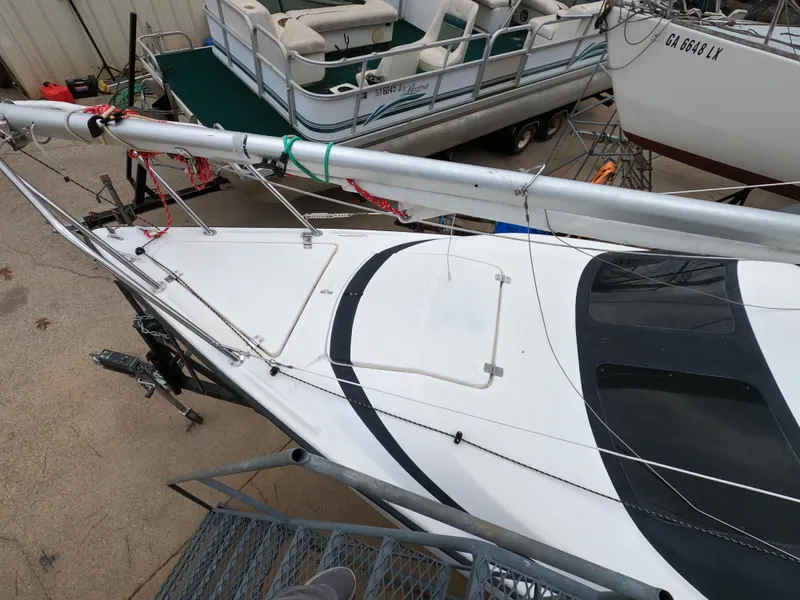 Slide: The Image of 2002 MacGregor 26X sailboat with mast, docked alongside other boats. - 5