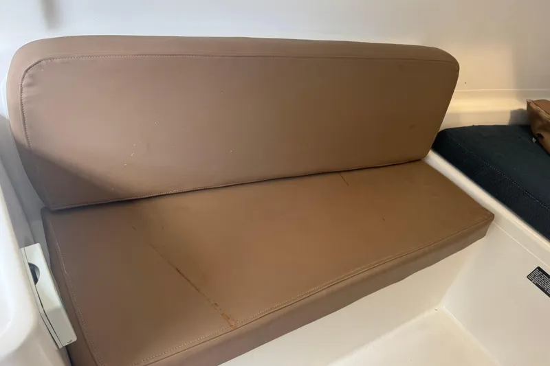 Slide: The Image of Brown cushioned seat inside a 2002 MacGregor 26X boat interior. - 9