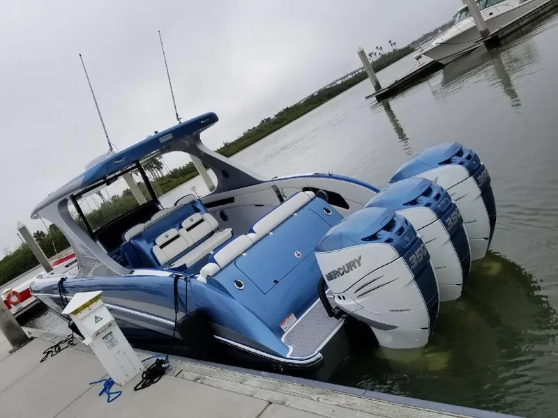 Slide: The Image of 2018 Mystic Powerboats M4200 with triple Mercury engines docked in a marina. - 28