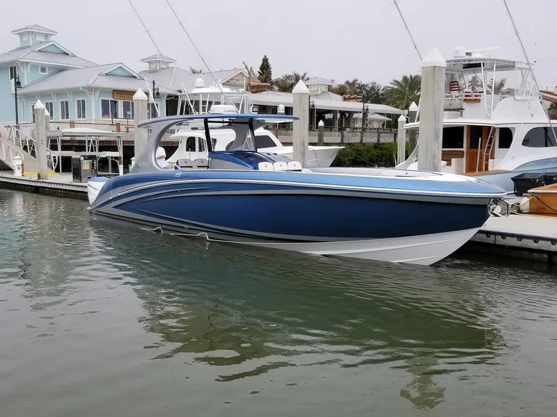 Slide: The Image of 2018 Mystic Powerboats M4200, blue and white, docked in a marina. - 29
