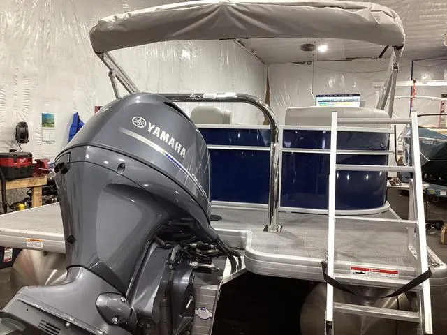 Slide: The Image of 2025 Godfrey Xperience 2286 SBX pontoon boat with Yamaha outboard motor in a garage. - 22
