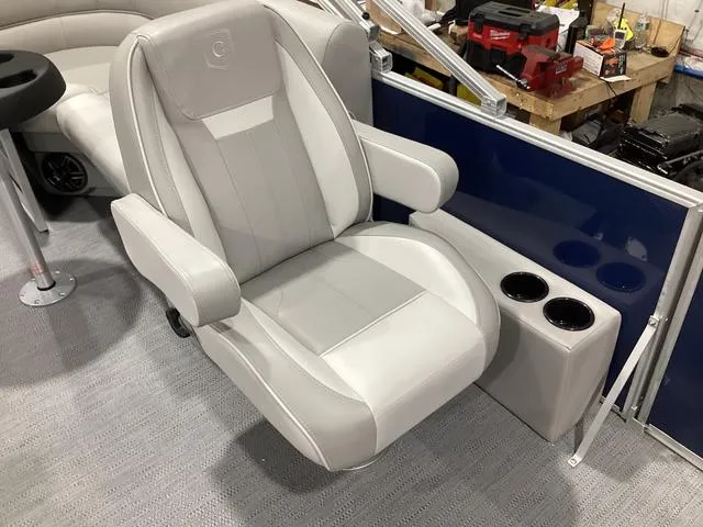 Slide: The Image of 2025 Godfrey Xperience 2286 SBX boat seat with cup holders, in a workshop setting. - 6