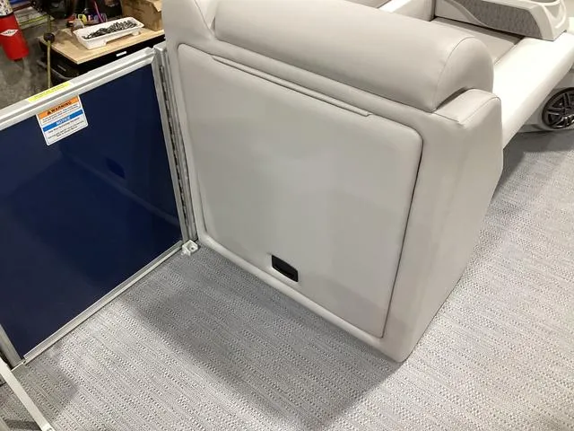 Slide: The Image of 2025 Godfrey Xperience 2286 SBX boat interior with cushioned seating and storage compartment. - 9