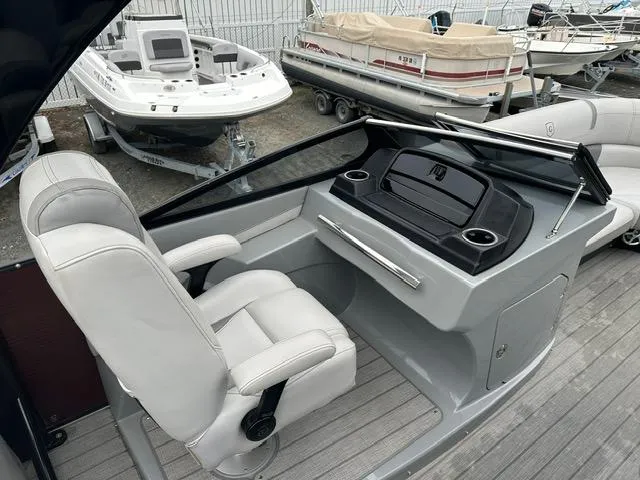 Slide: The Image of 2018 Godfrey Aqua Patio 259ULW Tri-Toon boat helm with white captain's chair and control panel. - 11