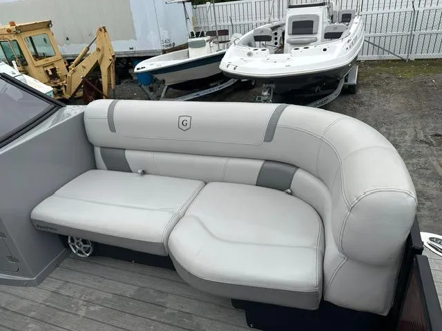 Slide: The Image of 2018 Godfrey Aqua Patio 259ULW Tri-Toon with white leather seating, docked near other boats. - 13