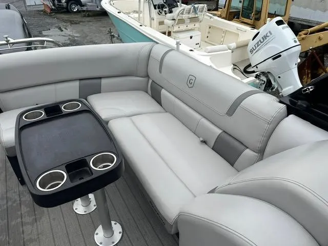 Slide: The Image of 2018 Godfrey Aqua Patio 259ULW Tri-Toon with seating and table, featuring Suzuki outboard motor. - 14