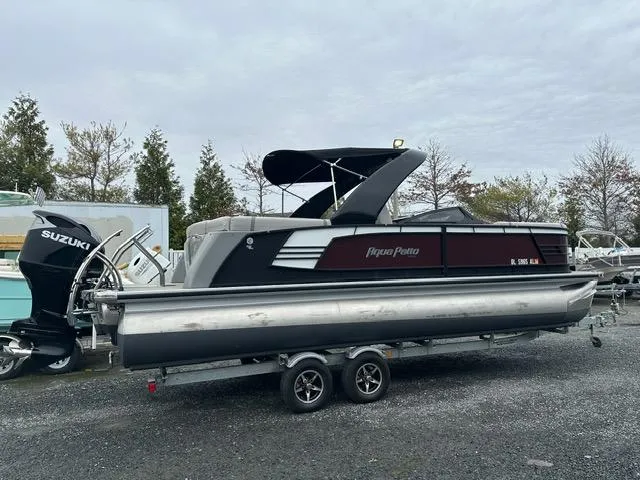 Slide: The Image of 2018 Godfrey Aqua Patio 259ULW Tri-Toon boat on trailer with Suzuki outboard motor. - 2