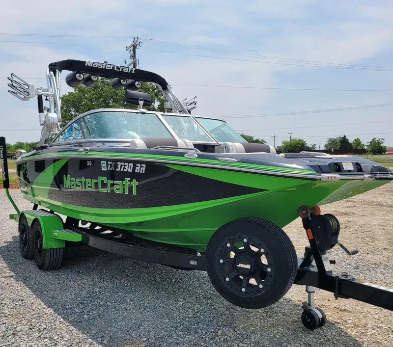 Slide: The Image of 2012 MasterCraft X25 boat in vibrant green on a trailer. - 11