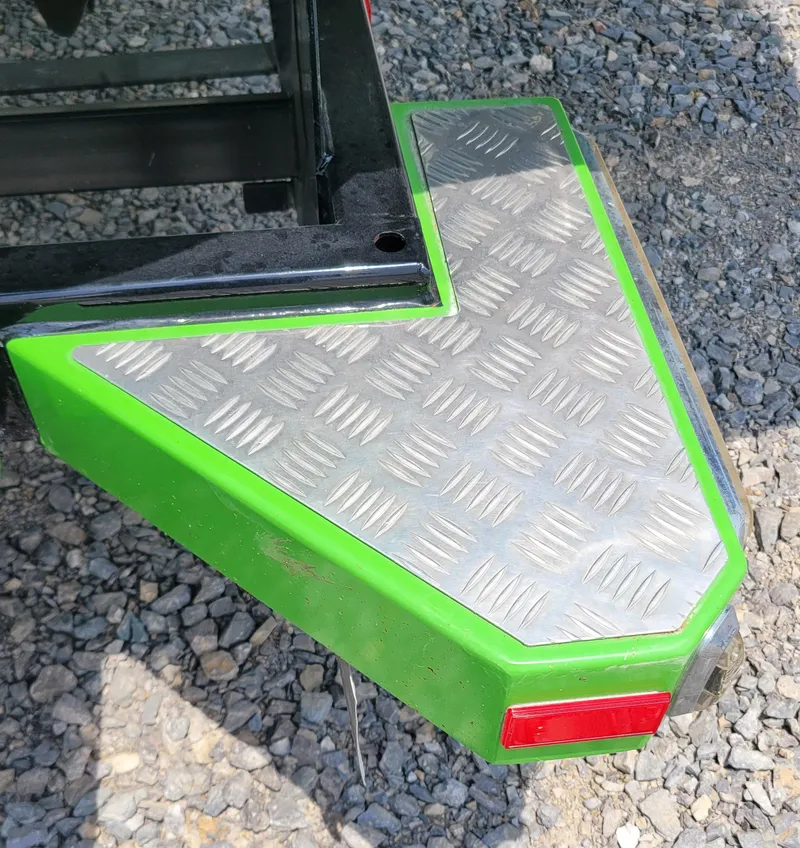 Slide: The Image of Green MasterCraft X25 2012 boat trailer with diamond plate step on gravel. - 14