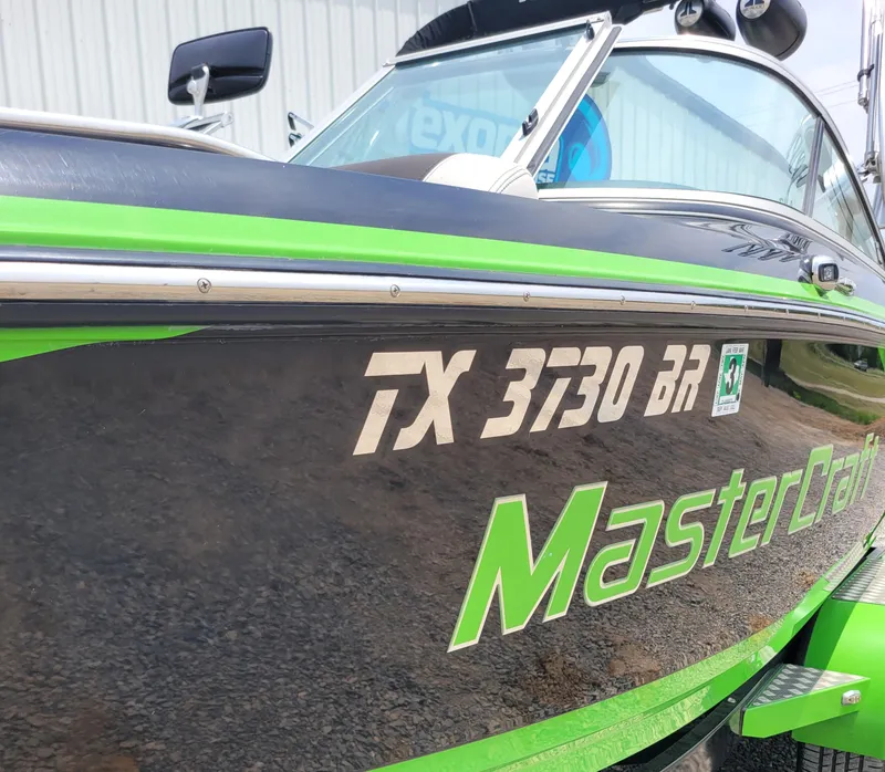 Slide: The Image of 2012 MasterCraft X25 boat with green accents and registration number TX 3730 BR. - 15