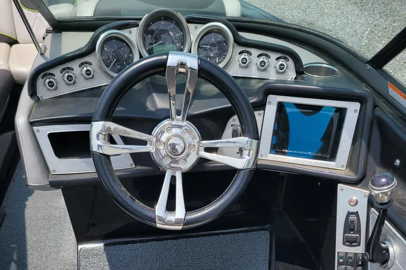Slide: The Image of 2012 MasterCraft X25 boat dashboard with steering wheel and control panel. - 20