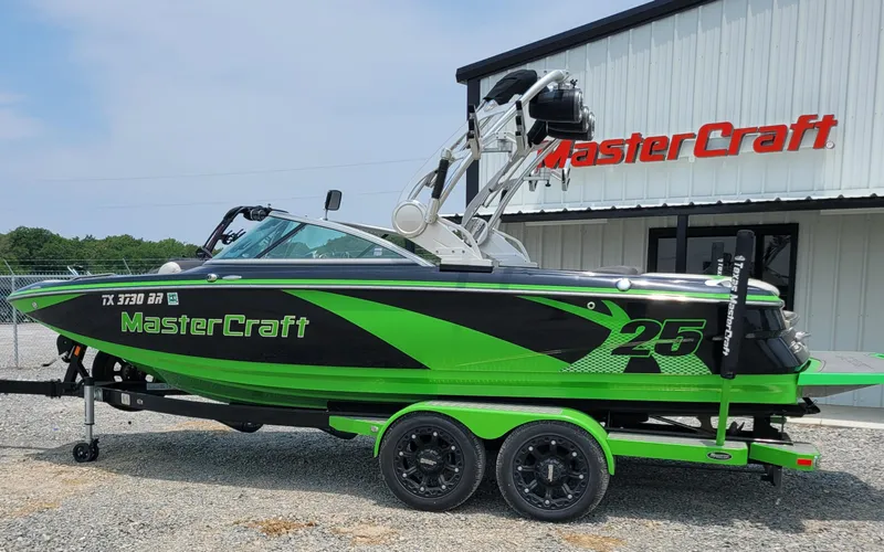 Slide: The Image of 2012 MasterCraft X25 boat in green and black, parked outside dealership. - 4