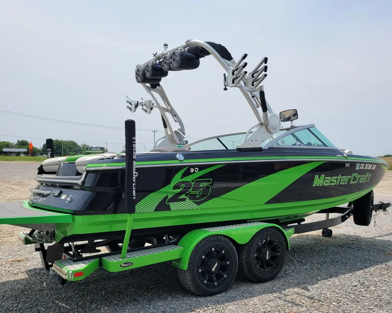 Slide: The Image of 2012 MasterCraft X25 boat in vibrant green and black on a trailer. - 8
