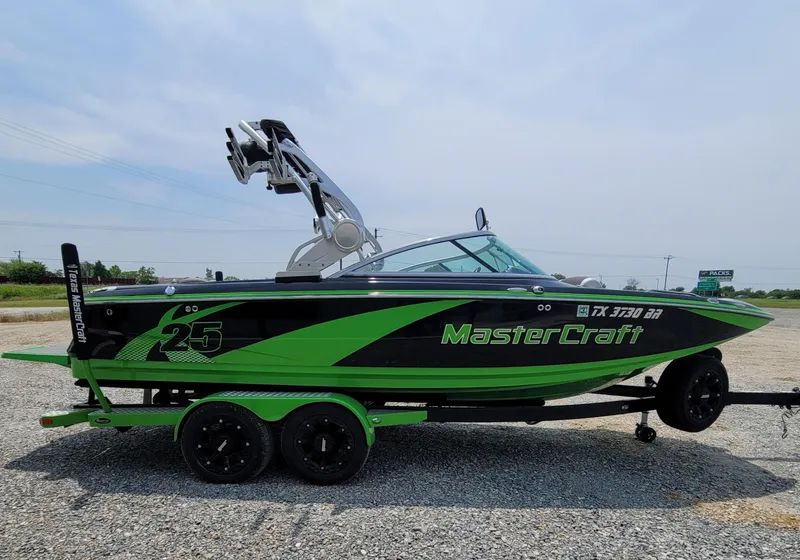 Slide: The Image of 2012 MasterCraft X25 boat in green and black on a trailer. - 9