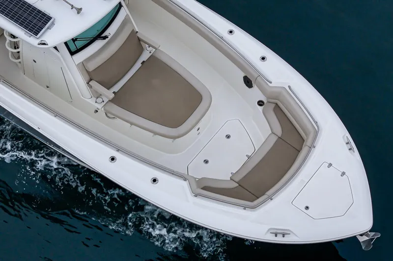Slide: The Image of 2019 Boston Whaler 330 Outrage boat with spacious seating, cruising on water. - 12