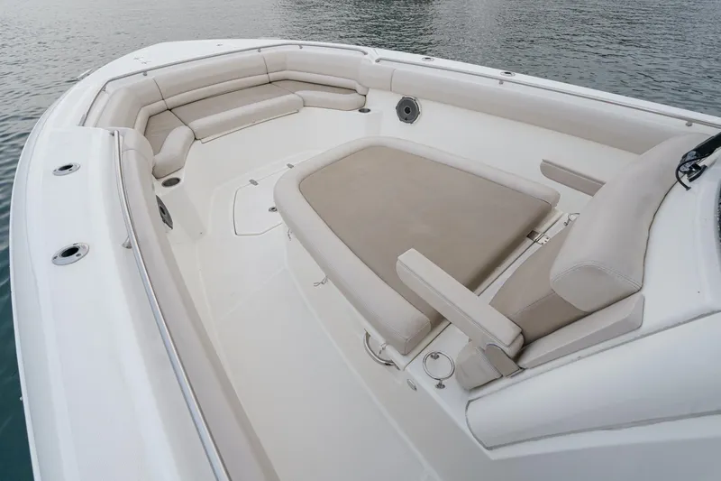 Slide: The Image of 2019 Boston Whaler 330 Outrage boat interior with cushioned seating and spacious deck. - 13