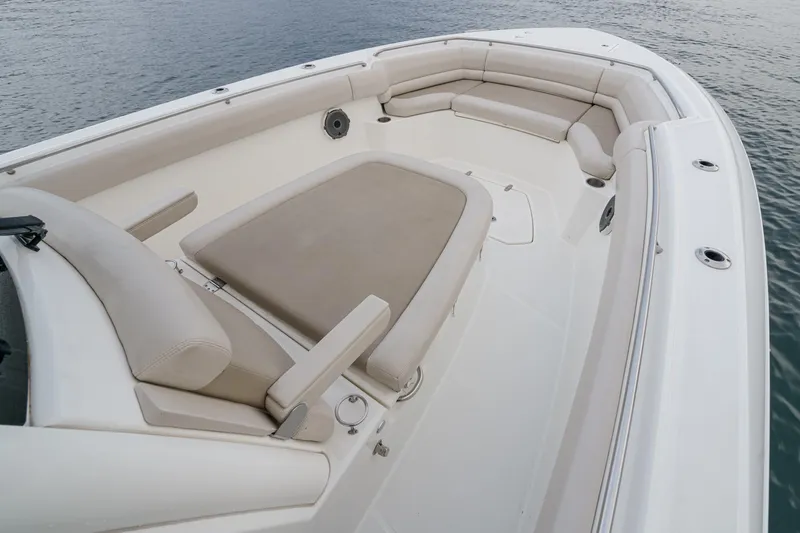 Slide: The Image of 2019 Boston Whaler 330 Outrage boat interior with cushioned seating and spacious deck. - 14