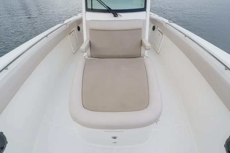 Slide: The Image of 2019 Boston Whaler 330 Outrage boat interior with cushioned seating area. - 15
