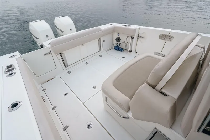 Slide: The Image of 2019 Boston Whaler 330 Outrage boat deck with seating and twin engines. - 20