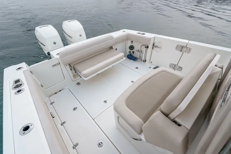 Slide: The Image of 2019 Boston Whaler 330 Outrage boat interior with seating and twin engines on water. - 21