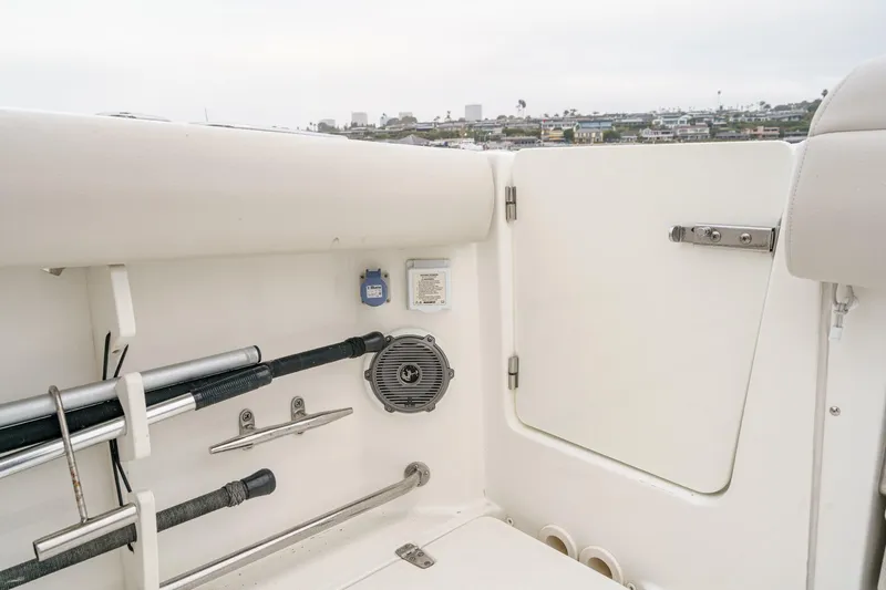 Slide: The Image of 2019 Boston Whaler 330 Outrage boat interior with rod holders and speaker. - 24