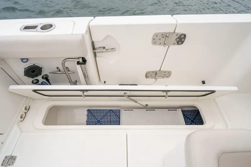 Slide: The Image of 2019 Boston Whaler 330 Outrage boat storage compartment with open hatch, showcasing interior details. - 25