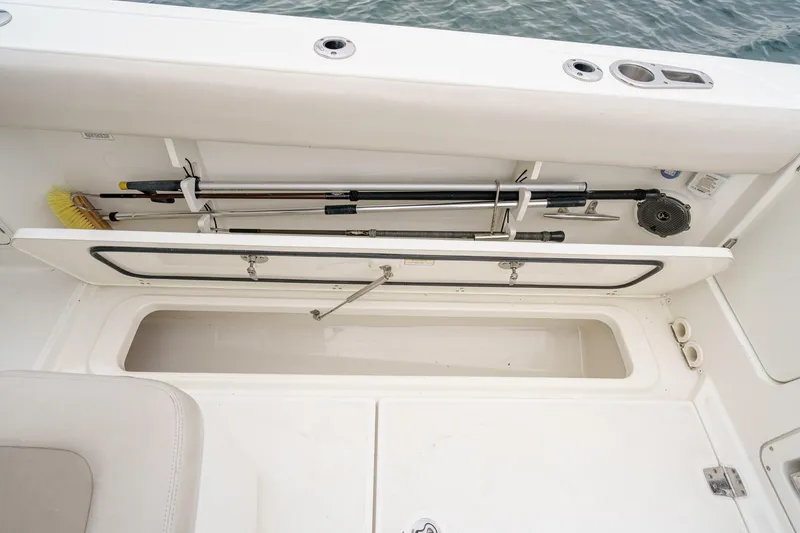 Slide: The Image of Storage compartment on a 2019 Boston Whaler 330 Outrage boat, featuring fishing gear. - 26
