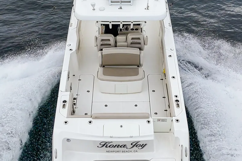 Slide: The Image of 2019 Boston Whaler 330 Outrage boat cruising on water, rear view. - 27