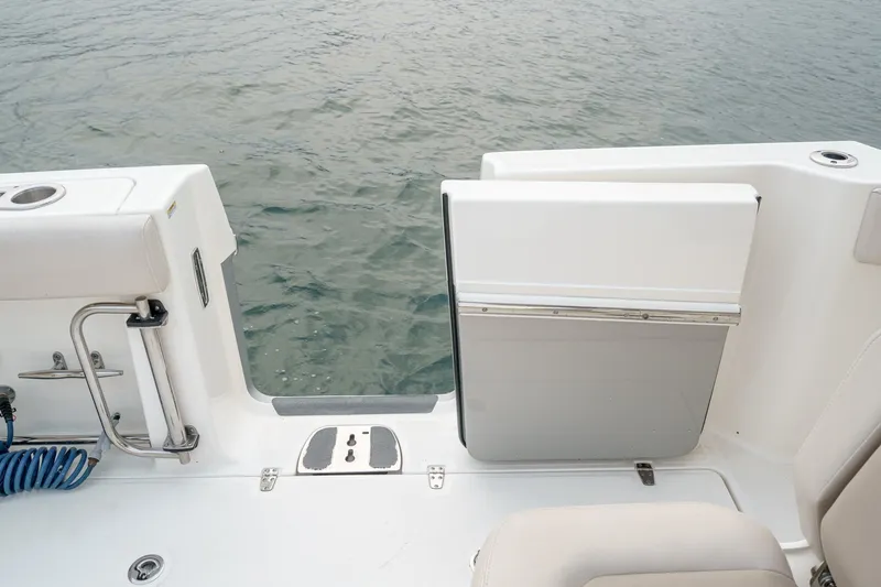 Slide: The Image of 2019 Boston Whaler 330 Outrage boat deck with open transom door, overlooking water. - 29