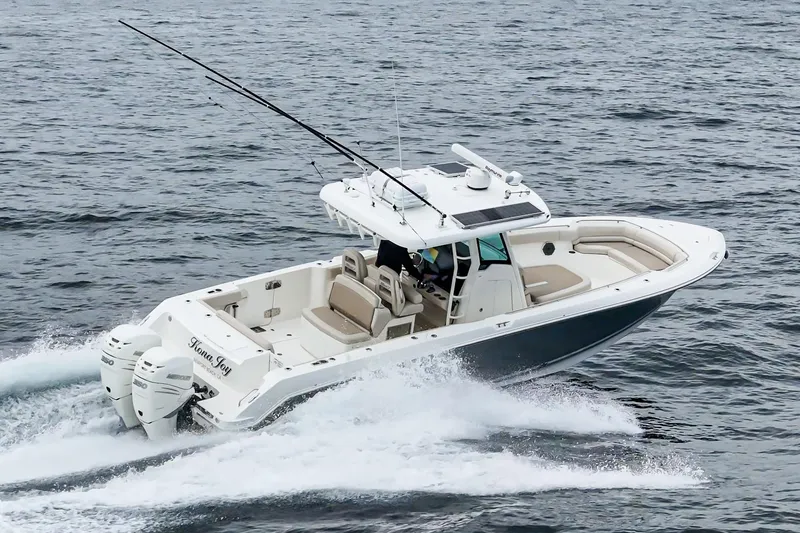 Slide: The Image of 2019 Boston Whaler 330 Outrage cruising on open water, showcasing sleek design and powerful engines. - 3