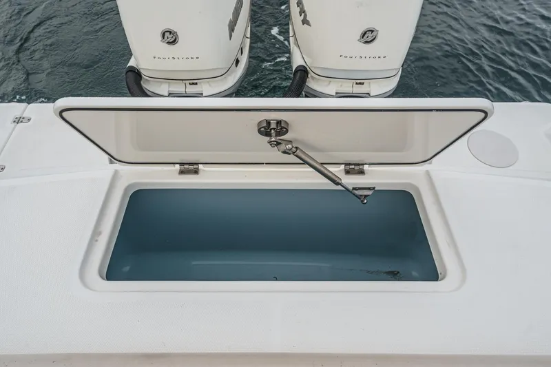 Slide: The Image of Open storage compartment on 2019 Boston Whaler 330 Outrage boat, with dual outboard motors. - 32
