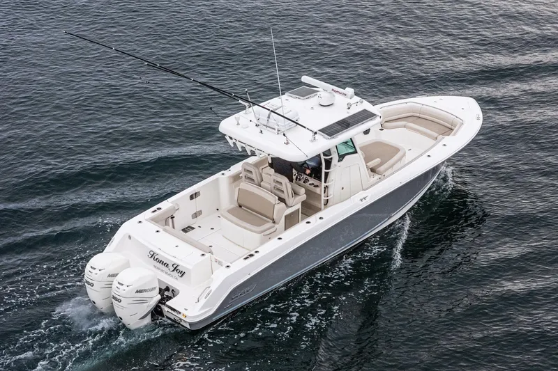 Slide: The Image of 2019 Boston Whaler 330 Outrage boat cruising on open water, featuring twin engines. - 33