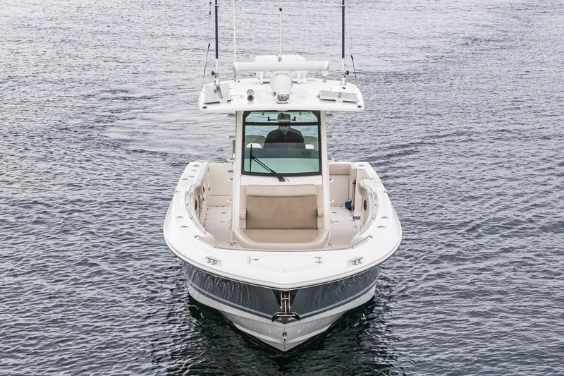 Slide: The Image of 2019 Boston Whaler 330 Outrage boat on calm water, front view. - 40