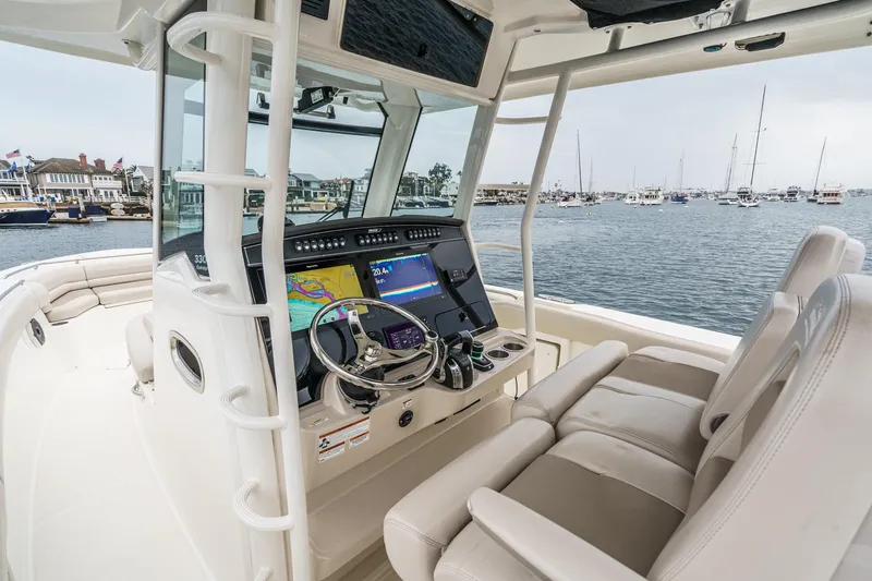 Slide: The Image of 2019 Boston Whaler 330 Outrage helm with advanced navigation system, docked in a marina. - 43
