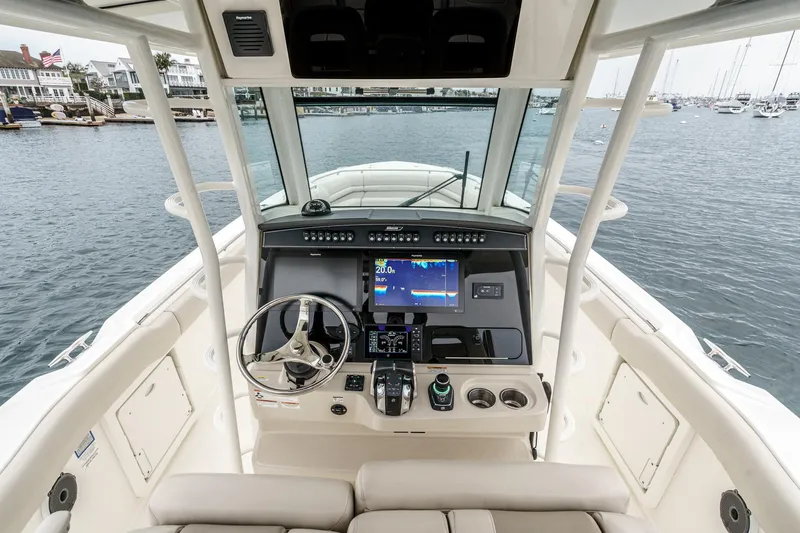 Slide: The Image of 2019 Boston Whaler 330 Outrage helm with advanced navigation system, docked in a marina. - 44