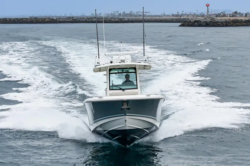 Slide: The Image of 2019 Boston Whaler 330 Outrage cruising on open water, creating a dynamic wake. - 5