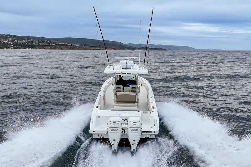 Slide: The Image of 2019 Boston Whaler 330 Outrage cruising on open water, rear view. - 9