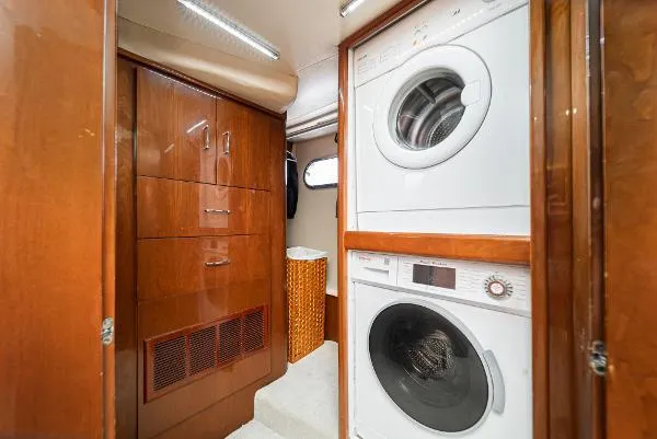 Slide: The Image of Laundry area in 2004 Marquis yacht with stacked washer and dryer, wooden cabinetry. - 31