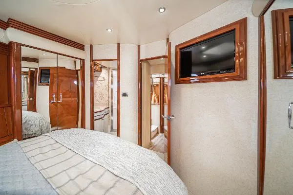 Slide: The Image of Luxurious 2004 Marquis yacht bedroom with TV, mirrored closet, and elegant wood finishes. - 36