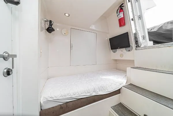 Slide: The Image of Compact cabin interior of 2004 Marquis boat with bed, TV, and fire extinguisher. - 40