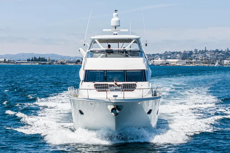Slide: The Image of Luxury 2004 Marquis yacht cruising on open water with scenic coastal backdrop. - 46