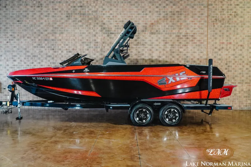 Slide: The Image of 2020 Axis T23 boat in red and black on trailer at Lake Norman Marina. - 1