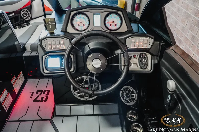 Slide: The Image of Axis T23 2020 boat dashboard with steering wheel and control panels at Lake Norman Marina. - 12
