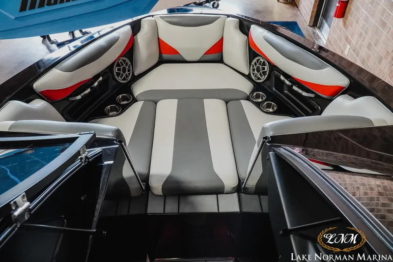 Slide: The Image of 2020 Axis T23 boat interior with gray and red seating, cup holders, and speakers. - 13