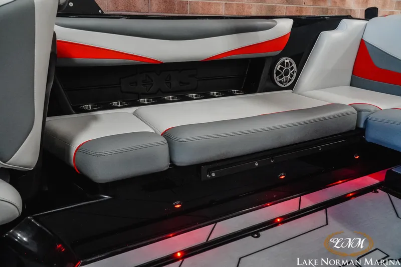Slide: The Image of 2020 Axis T23 boat interior with gray and red seating, cup holders, and speaker. - 16