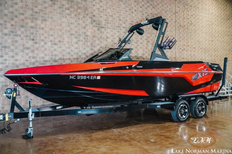 Slide: The Image of 2020 Axis T23 boat in red and black on trailer at Lake Norman Marina. - 2