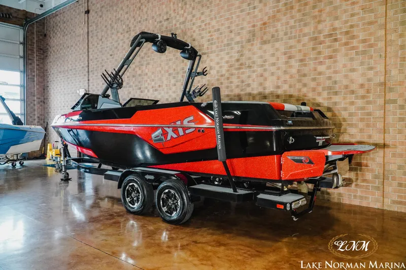 Slide: The Image of 2020 Axis T23 boat in showroom, red and black design, on trailer. - 3