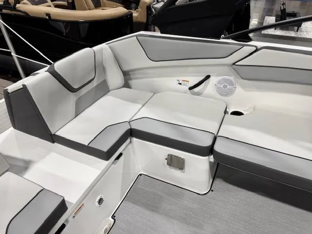 Slide: The Image of 2025 Yamaha Boats AR220 interior seating with gray and white upholstery, featuring a speaker and cup holder. - 9