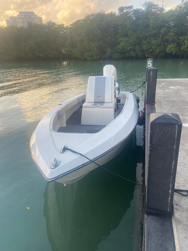 Slide: The Image of 1987 Paramount 21 boat docked on calm water at sunset. - 10