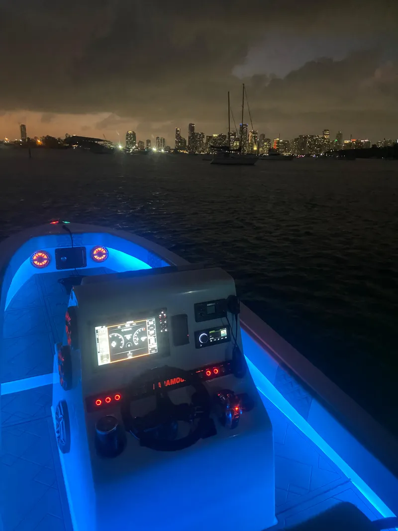 Slide: The Image of 1987 Paramount 21 boat with illuminated dashboard, city skyline at night. - 11